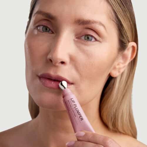 Echte Rosental Organics Lip Plumper Erfahrungen und Testergebnisse – inkl. aktuellem Rabattcode. Frau trägt den Rosental Organics Lip Plumper mit dem Applikator auf die Lippen auf.